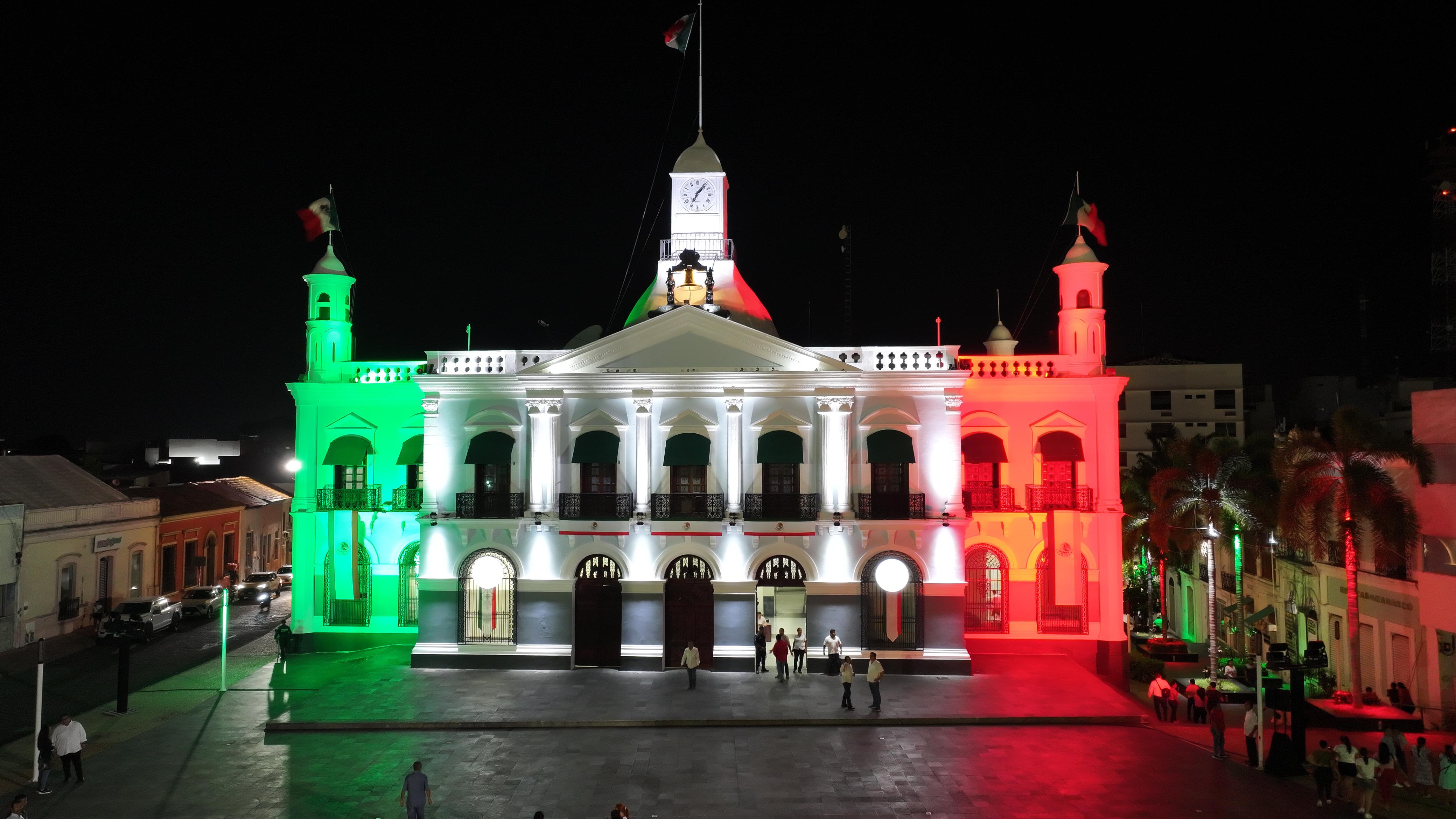 Inician las celebraciones del mes patrio con iluminación de edificios públicos en verde, blanco y rojo.